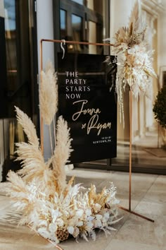 the party starts now sign and flowers on display in front of an entrance to a building