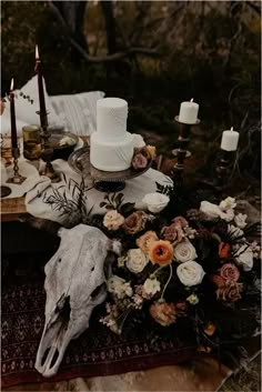 a table topped with a white cake next to candles and other decorating items on top of a rug