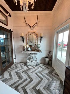 a room with a chevron floor and chandelier