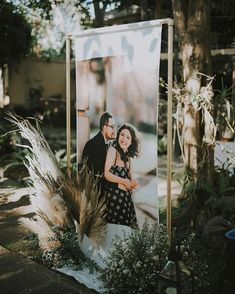 a couple is posing in front of an outdoor photo