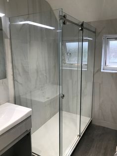 a bathroom with a walk in shower next to a sink