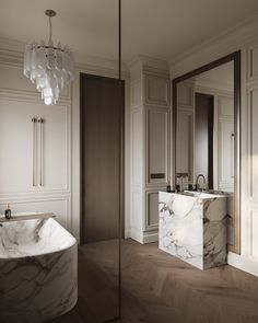 an elegant bathroom with marble counter tops and bathtub, chandelier and mirror