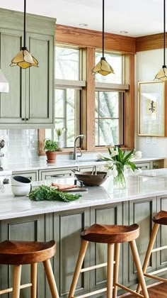 a kitchen with wooden stools and green cabinets