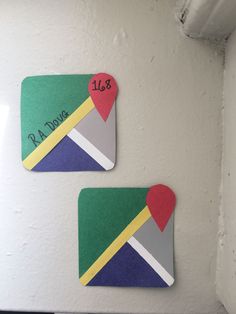 two magnets that have been placed on the side of a refrigerator with a heart