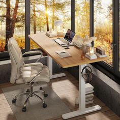 a computer desk with a laptop on it in front of a window overlooking the woods