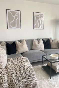 a living room filled with lots of furniture and pillows on top of a white rug