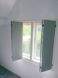 an empty room with two open windows on the wall and one closed window in the middle