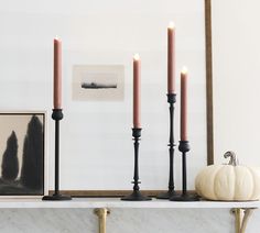 three candles sitting on top of a mantle