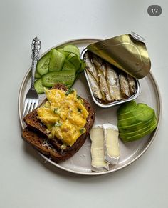 a plate with some food on it including bread, pickles and other items to eat