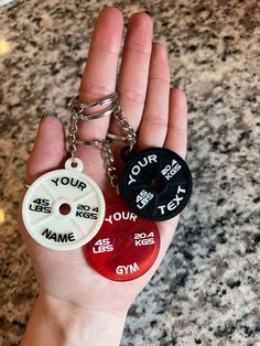 two personalized key chains in the palm of someone's hand