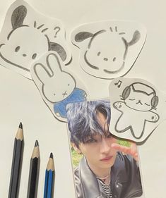 an image of a boy with blue hair and some pencils