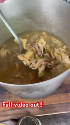 a large bowl filled with soup sitting on top of a wooden table