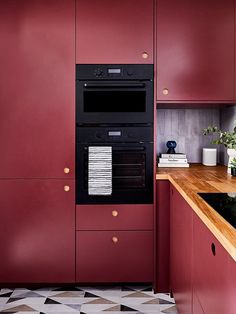 a kitchen with red cabinets and an oven in the center, next to a counter