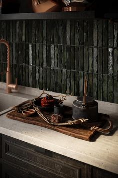 a wooden cutting board sitting on top of a counter next to a faucet