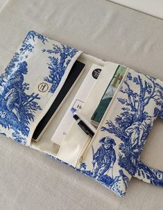 a blue and white toiler print case with pens, scissors and notebooks