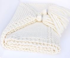 a white knitted blanket laying on top of a table