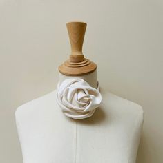 a mannequin with a white flower on it