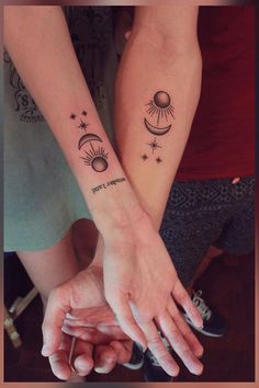 two people holding hands with tattoos on them