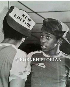 an old black and white photo of two young men wearing new york baseball caps, looking at each other