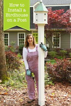 a woman standing next to a post with a bird house on it and the words how to install a birdhouse on a post