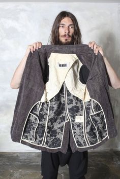 a man holding up a piece of cloth that has been made into an apron and jacket