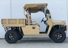 a tan utility vehicle parked in front of a building