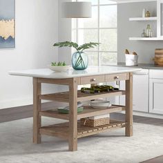 a kitchen island with white marble top and wooden shelves in front of a large window