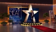 a man standing on top of a red carpet in front of a giant star sign