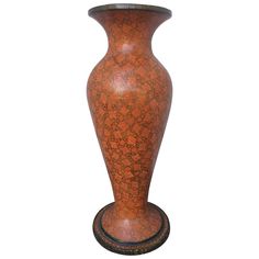 a brown vase sitting on top of a wooden stand