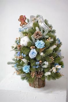 a small christmas tree with blue and white flowers