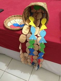 a basket filled with paper cutouts sitting on top of a floor next to a table