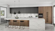 a modern kitchen with marble counter tops and stools