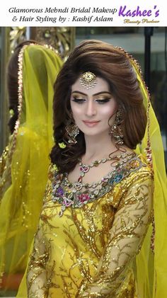 a woman in a yellow dress with jewelry on her head and veil over her face