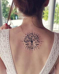 a woman with a tree tattoo on her back