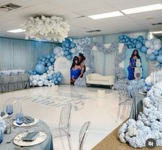 two women in blue dresses are sitting on the dance floor surrounded by balloons and chairs