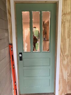 a green door is being installed on the side of a house