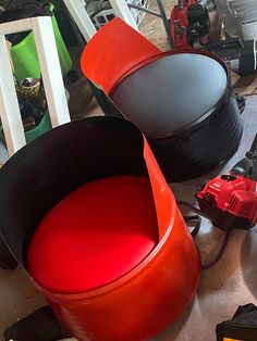 two red chairs sitting next to each other on top of a floor covered in tools