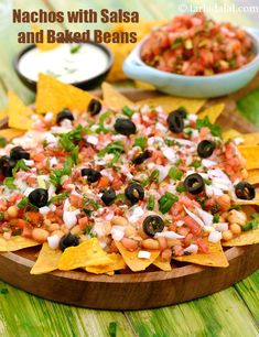 nachos and salsa on a wooden platter