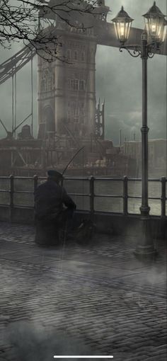 a man sitting on a bench in front of the water under a street light and lamp post