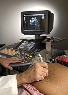 a man in a hospital bed with an x - ray machine on his stomach and arm