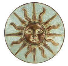 a ceramic plate with an image of the sun on it's face in gold and green