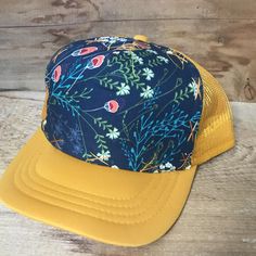 This floral design is always a good choice. Goes with everything. All hats have a terry cloth lining, mesh back, and snap adjustable back. We believe in individual expression, hand crafting, and getting outside. Our hats are meant to instill adventure in you whenever you wear them! All our hats are hand stitched by us, local women, or our team of lady stay at home mom seamstresses in L.A. Every hat is unique as they are not mass produced. We buy our fabrics from small fabric designers or work cl Festival 5-panel Trucker Hat One Size, Festival 5-panel Trucker Hat, Casual Floral Print Cap, Spring Beach Trucker Hat, 5-panel, Adjustable Baseball Cap Trucker Hat For Festivals, Spring Beach Snapback Hat, 5-panel, Yellow Cotton Trucker Hat With Curved Brim, Adjustable Curved Brim Trucker Hat For Festivals, Casual Yellow Reversible Sun Hat