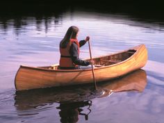 a woman in a canoe paddling on the water