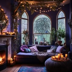 a living room filled with lots of furniture and candles in front of two large windows