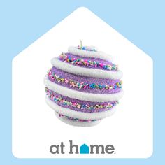 a purple cake with sprinkles on it and the words at home above it