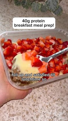 a person holding a plastic container with strawberries and ice cream in it that says, 40g protein breakfast meal prep