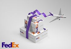 an airplane is flying over boxes that are tied with purple ribbon and labeled fedex