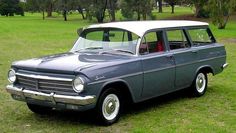 an old car is parked in the grass