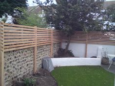 a backyard with a tree and fence in the back yard, next to a patio