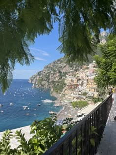 a scenic view of the ocean with boats in the water and houses on the hillside